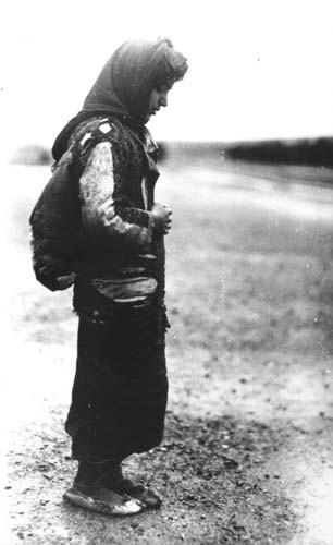 An Armenian refugee, wearing a scarf and a pack on her back.