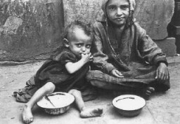 Children eating in the ghetto streets. Warsaw, Poland, between 1940 and 1943. [LCID: 89473]